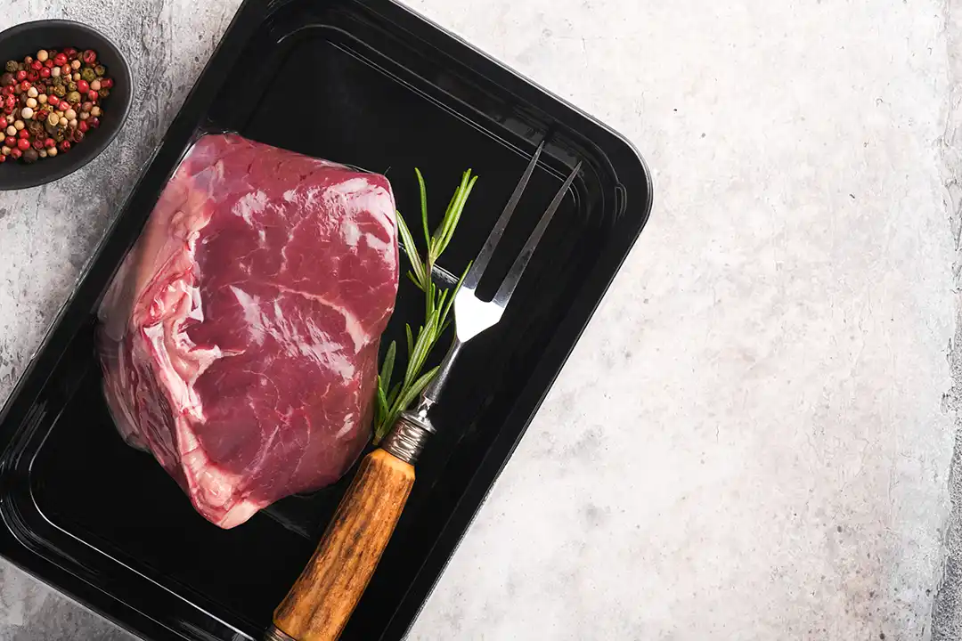 Vitrina refrigerada profesional con bandejas de presentaci&oacute;n negras y blancas resaltando producto fresco